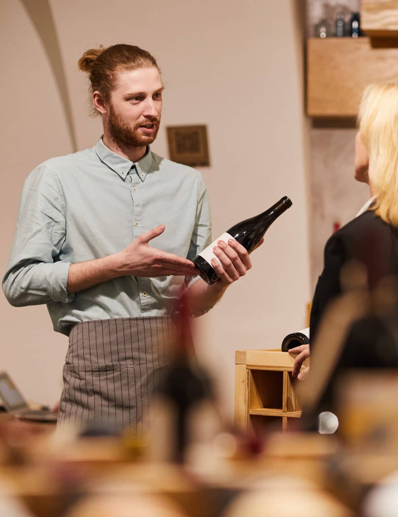 Consulting Client in Winery Portrait of contemporary man consulting customer in liquor store, copy space